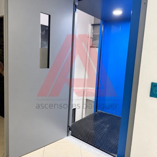 Cabina del montacargas hidráulico de 2 toneladas vista desde la puerta de piso abierta, en Medellín